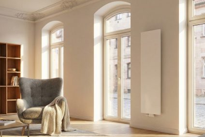 Hell eingerichtetes Wohnzimmer im Nürnberger Altbau mit freistehendem Heizkörper zur optimalen Wärmeverteilung.