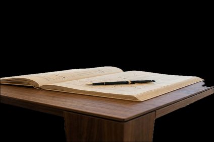 Ein Vertrag für einen Immobilienkredit wird mit einem Füller geprüft, um fehlerhafte Widerrufsbelehrungen in Nürnberg zu finden.