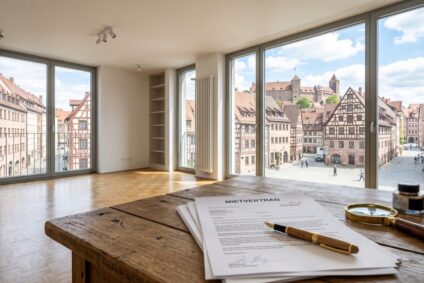 Mietminderung-schimmel-wohnung-nuernberg | Maderer Immobilien Helle, Moderne Mietwohnung in Nürnberg Mit Blick Auf Fränkische Altbaustruktur; Im Vordergrund Liegen Mietvertrag Und Lupe Auf Einem Holztisch Zum Thema Mietminderung Bei Schimmelbefall.