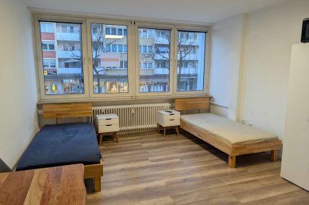Lichtdurchfluteter Wohnbereich der 1-Zimmer-Wohnung mit großer Fensterfront in Nürnberg.