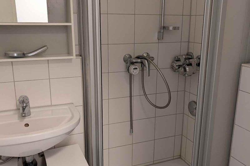 Gepflegtes, hell gefliestes Badezimmer mit Dusche und moderner Ausstattung.