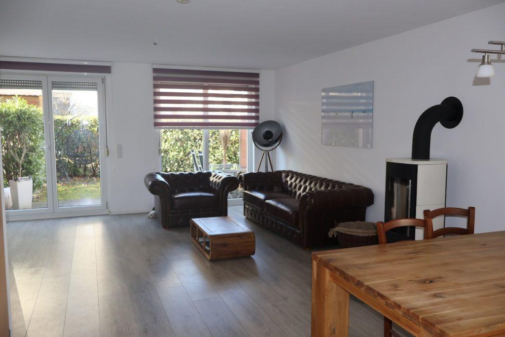 Gemütliches Wohnzimmer Mit Hochwertigen Ledersofas Und Modernem Schwedenofen Für Behagliche Abende.