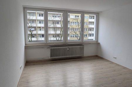 Helles Wohnzimmer mit Laminatboden und großem Fenster in Nürnberg-Maxfeld.