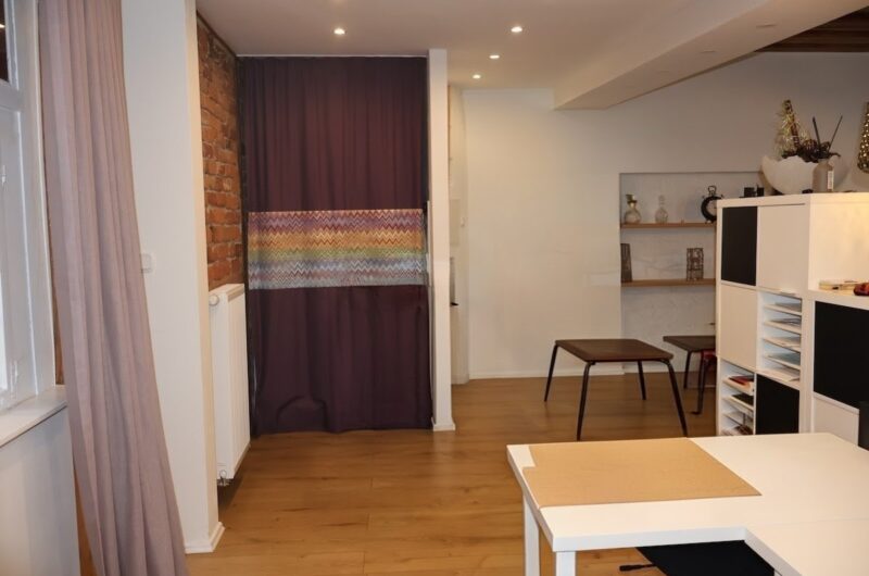 Einladender Empfangsbereich mit Counter und Akzentwand aus Backstein – Maderer Immobilien Nürnberg.