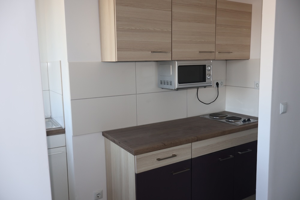 Moderne Einbauküche Mit Dunklen Fronten Und Viel Stauraum in Einer Nürnberger Wohnung.