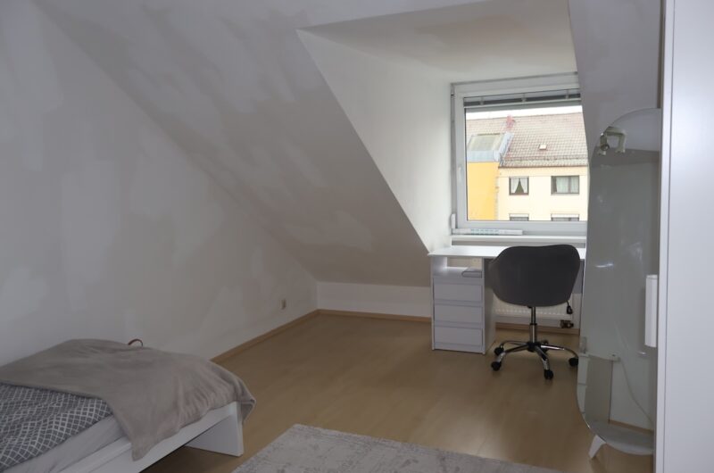 Hell beleuchtetes Zimmer mit Dachschräge, ideal als Büro oder Kinderzimmer nutzbar.