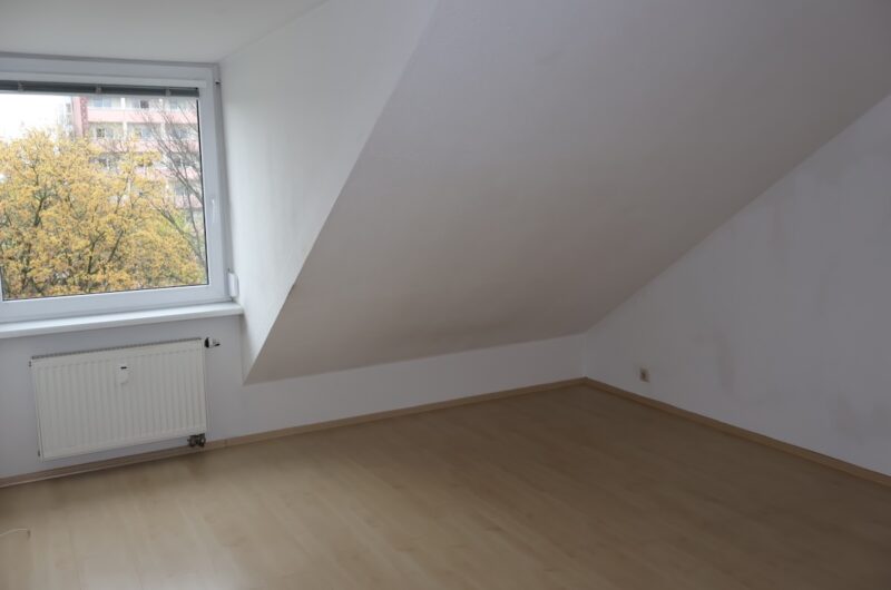 Geräumiges Schlafzimmer mit Laminatboden und Fenster im Dachgeschoss.