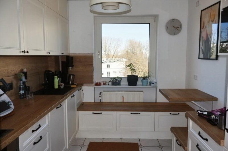 Küche im Landhausstil mit Sitzbank am Fenster und viel Stauraum