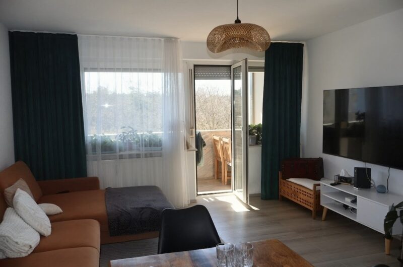 Helles Wohnzimmer mit Zugang zum Süd-West Balkon und Außenrollos