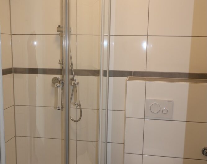 Komplett saniertes Badezimmer mit Duschkabine und Waschmaschinenanschluss.