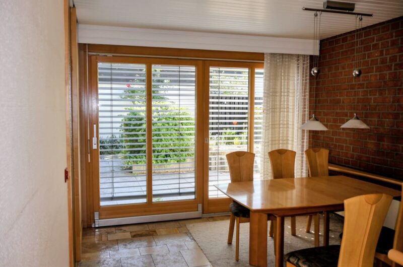 Heller Essbereich mit stilvollem Sichtmauerwerk und direktem Zugang zur überdachten Terrasse im Bungalow.