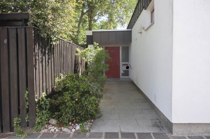 Einladender und überdachter Eingangsbereich eines gepflegten Bungalows.