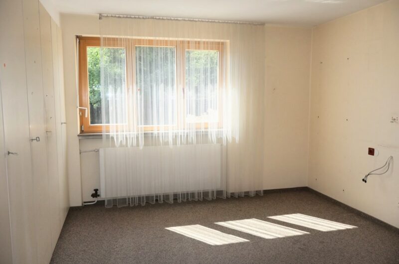 Lichtdurchflutetes Schlafzimmer oder Kinderzimmer mit großen, erneuerten Holzfenstern.