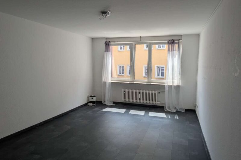 Helles Wohnzimmer im 1. OG einer Nürnberger Altstadt-Wohnung mit edlen dunklen Fliesen und großen Fenstern am Albrecht-Dürer-Platz.