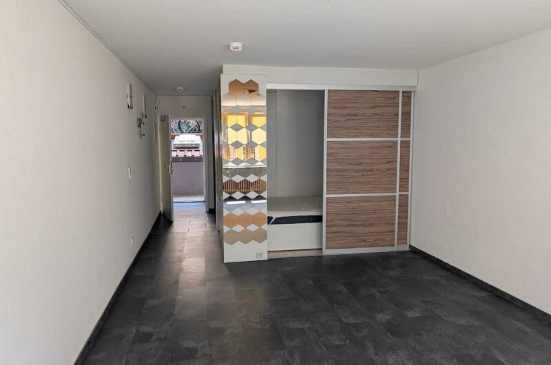 Cleveres Raumkonzept: Maßgefertigte Schrankwand mit integriertem Schlafbereich, Schiebetüren und Spiegel-Details in einem sanierten Apartment in Nürnberg.