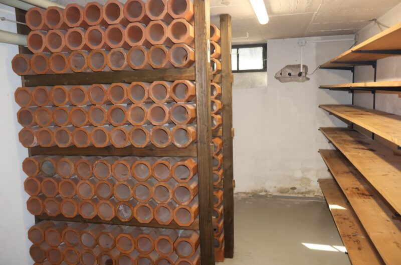 Praktischer Vorratsraum im Keller, aktuell ausgestattet als Weinlager mit Tonröhren.