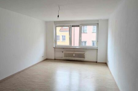 Helles, saniertes Wohnzimmer der 1-Zimmer-Wohnung in der Nürnberger Altstadt mit gepflegtem Laminatboden und großem Fenster nahe dem Albrecht-Dürer-Platz.