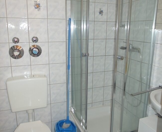 Raumhoch gefliestes Badezimmer mit Duschkabine in der 1,5-Zimmer-Wohnung in Nürnberg.