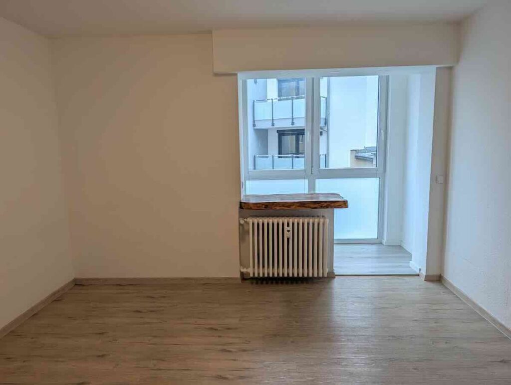 Wohnbereich Mit Laminatboden Und Offenem Blick in Den Angrenzenden Wintergarten Einer 1-zimmer-wohnung.