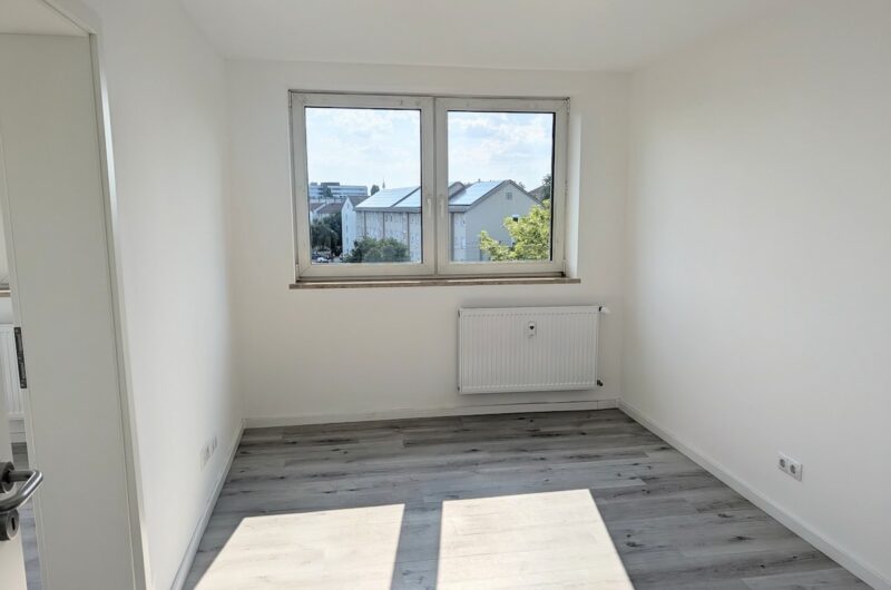 Großes Zimmer mit viel Tageslicht, Fensterfront und Vinylboden in Nürnberger Balkonwohnung Zabo, Maderer Immobilien.