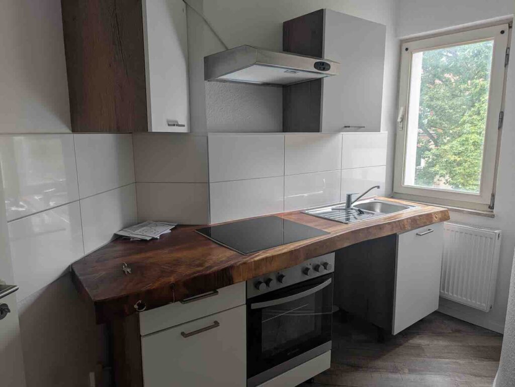Moderne Einbauküche Mit Echtholz-optik Arbeitsplatte in Nürnberger Wohnung