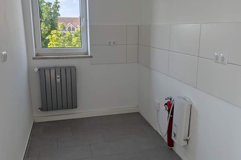 Moderner Küchenbereich mit hellen Wandfliesen und Vorbereitung für Einbauküche in Nürnberg-Zabo, Maderer Immobilien.