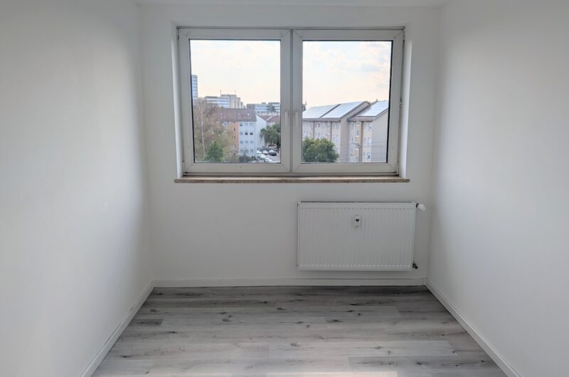 Hell beleuchtetes Zimmer mit großem Fenster, Heizkörper und Vinylboden in Wohnung in Zabo, Maderer Immobilien.