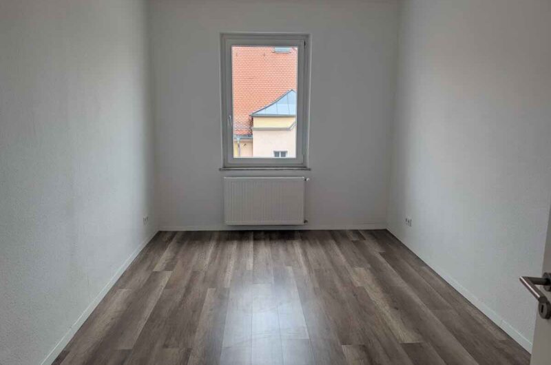 Gemütliches Schlafzimmer mit großem Fenster und Laminatboden in Nürnberg