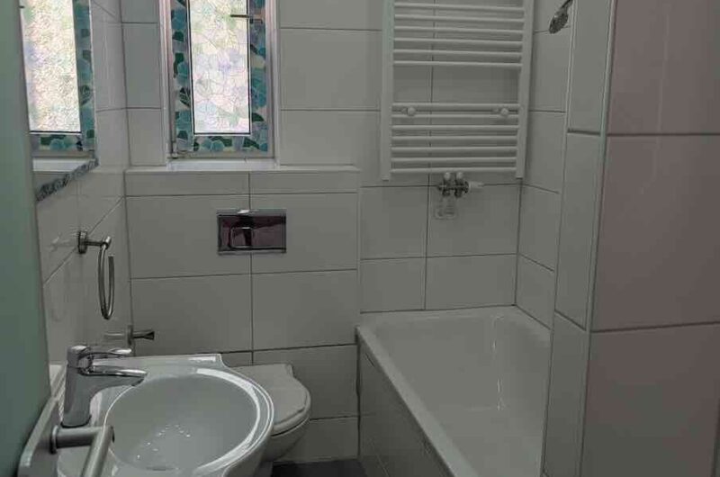Gepflegtes Tageslichtbad mit Badewanne, weißen Fliesen und Handtuchheizkörper in der Nürnberger Südstadt – vermittelt durch Maderer Immobilien.