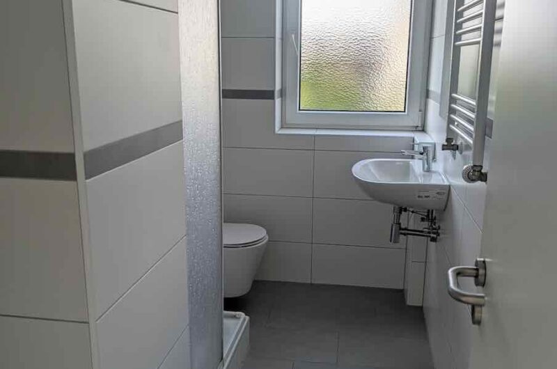 Komplett modernisiertes Tageslichtbad mit Dusche, WC, Handtuchheizkörper und Fenster in Wohnung in Zabo, Maderer Immobilien.