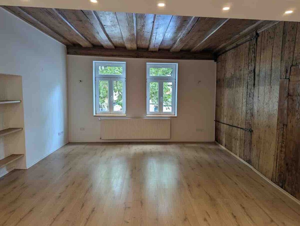 Helles Wohnzimmer Mit Originaler Holzbalkendecke Und Großen, Modernen Fenstern Im Nürnberger Zentrum.