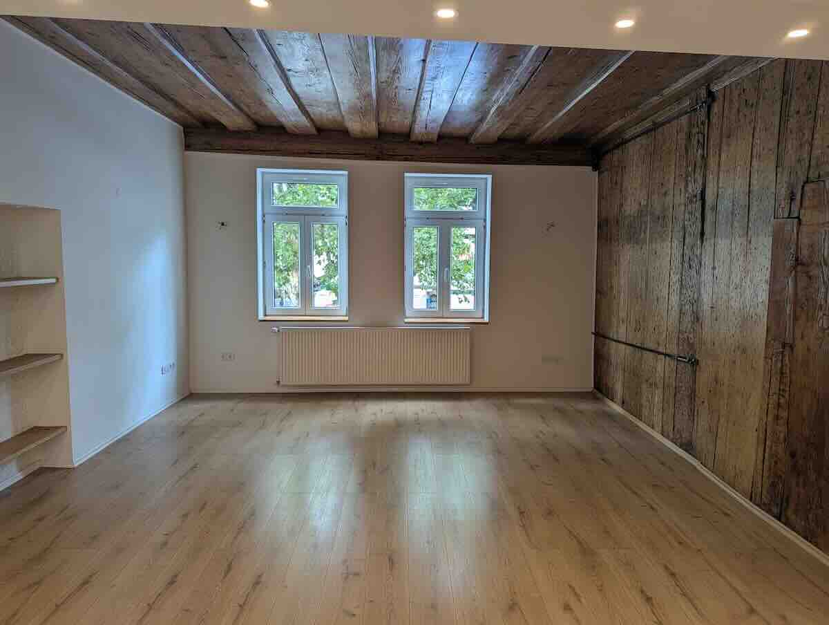 Helles Wohnzimmer Mit Originaler Holzbalkendecke Und Großen, Modernen Fenstern Im Nürnberger Zentrum.
