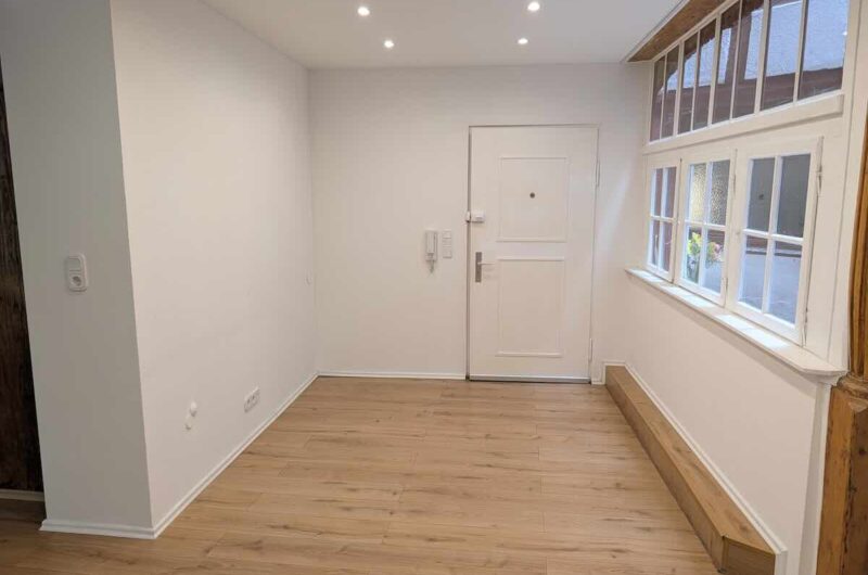Einladender Eingangsbereich mit stilvollem Holzfußboden und charakteristischen Sprossenfenstern.