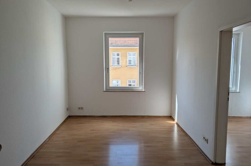 Wohnzimmer-2-zimmer-wohnung-nuernberg | Maderer Immobilien Geräumiges Wohnzimmer Mit Großem Fenster Und Laminat in 2-zimmer-wohnung.