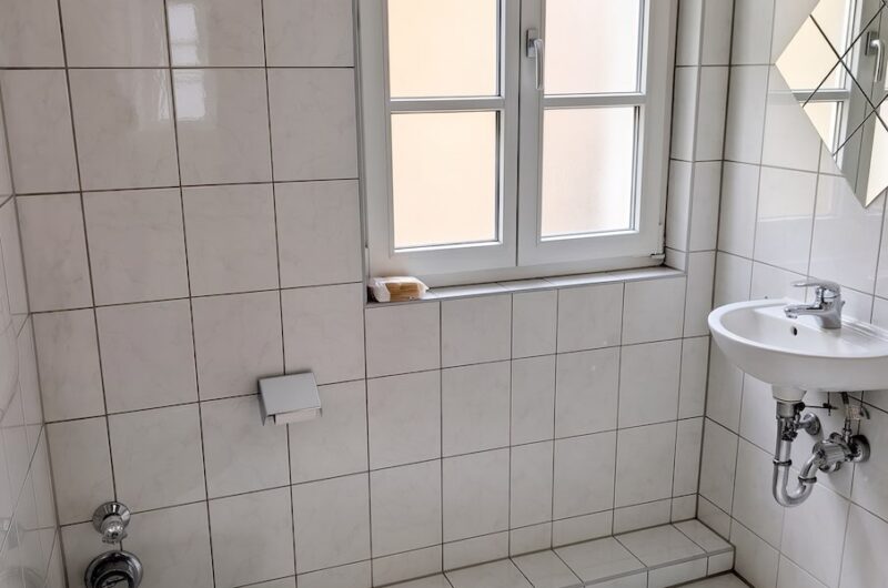 Praktisches Gäste-WC mit Altbaufenster und integriertem Waschmaschinenanschluss in der City-Wohnung Schwabach – Maderer Immobilien.