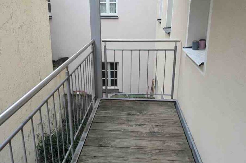Ruhiger Holzbalkon mit Edelstahlgeländer im Innenhof der historischen Mietwohnung in Schwabach – Maderer Immobilien.