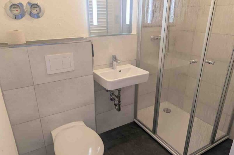 Frisch saniertes, stilvolles Badezimmer mit moderner Glasdusche in Nürnberg – ideal zur Erfrischung nach dem Sport. Maderer Immobilien.